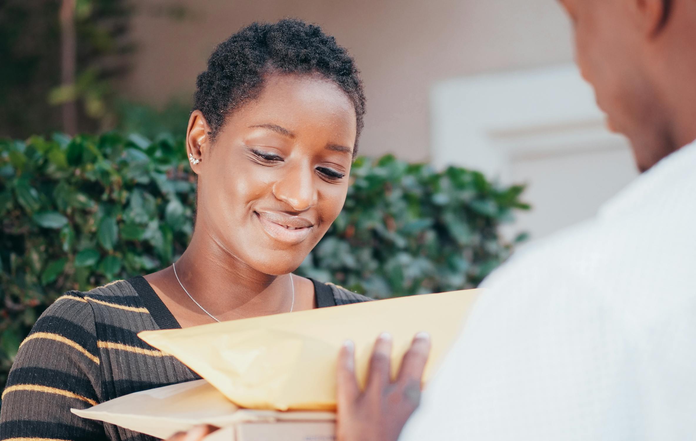 Woman happily receiving a delivery package at her front door
